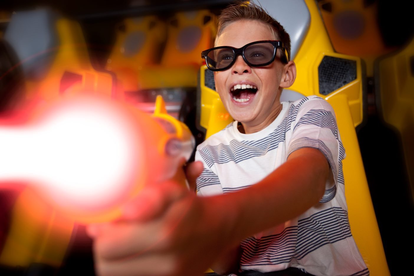 A rider firing a blaster in the Combat Ops dark ride theater