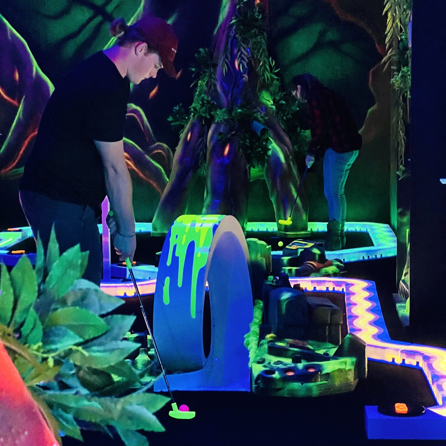 A neon-lit hole on the Meltdown Mini Golf course at Combat Ops